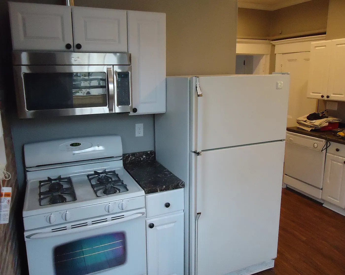 A kitchen with a fridge, oven and microwave