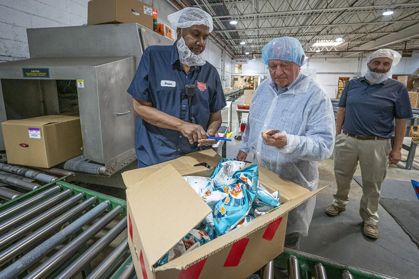 Workers packing snack products on a production line