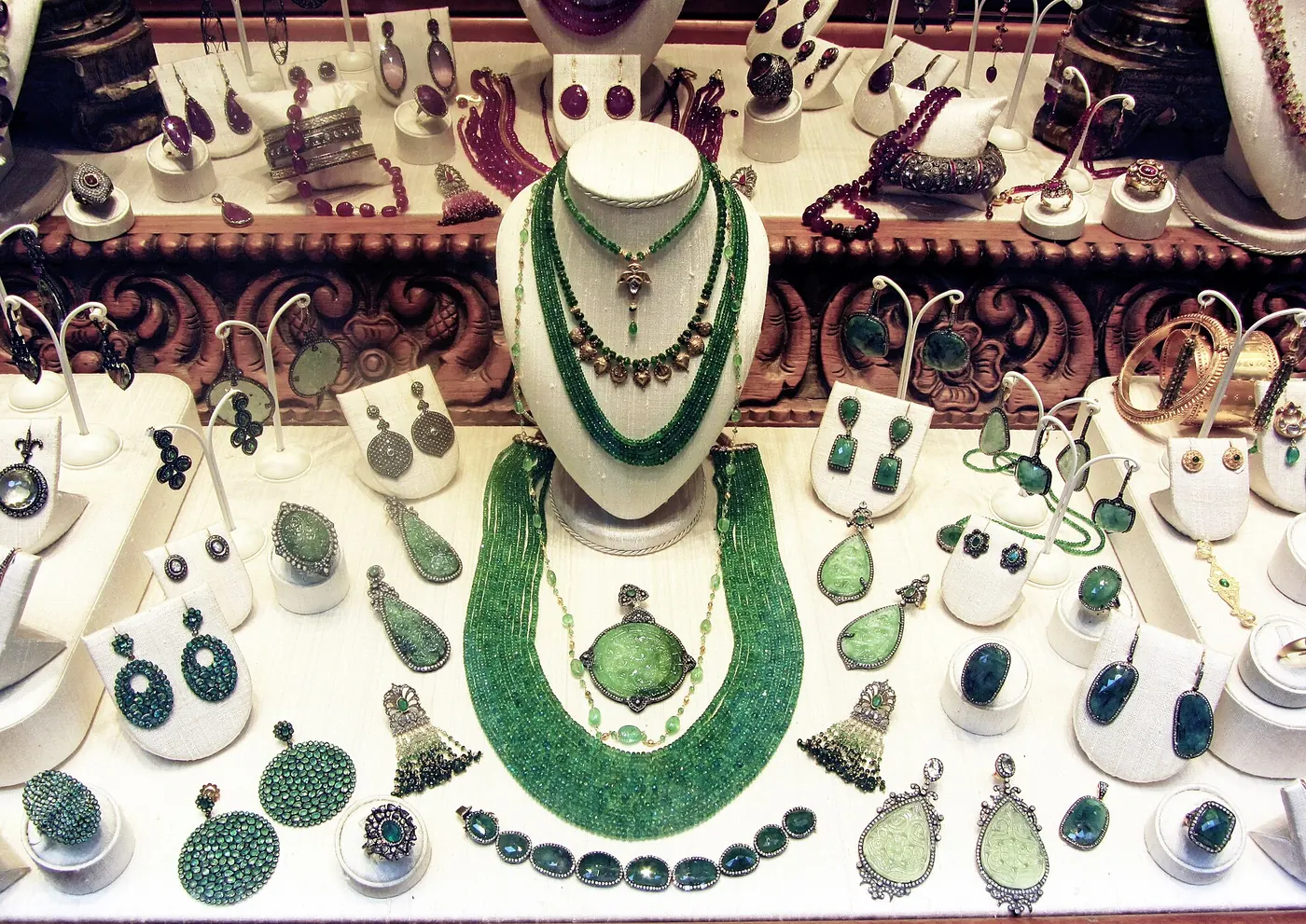 A jewellery display of necklaces, earrings and green stones