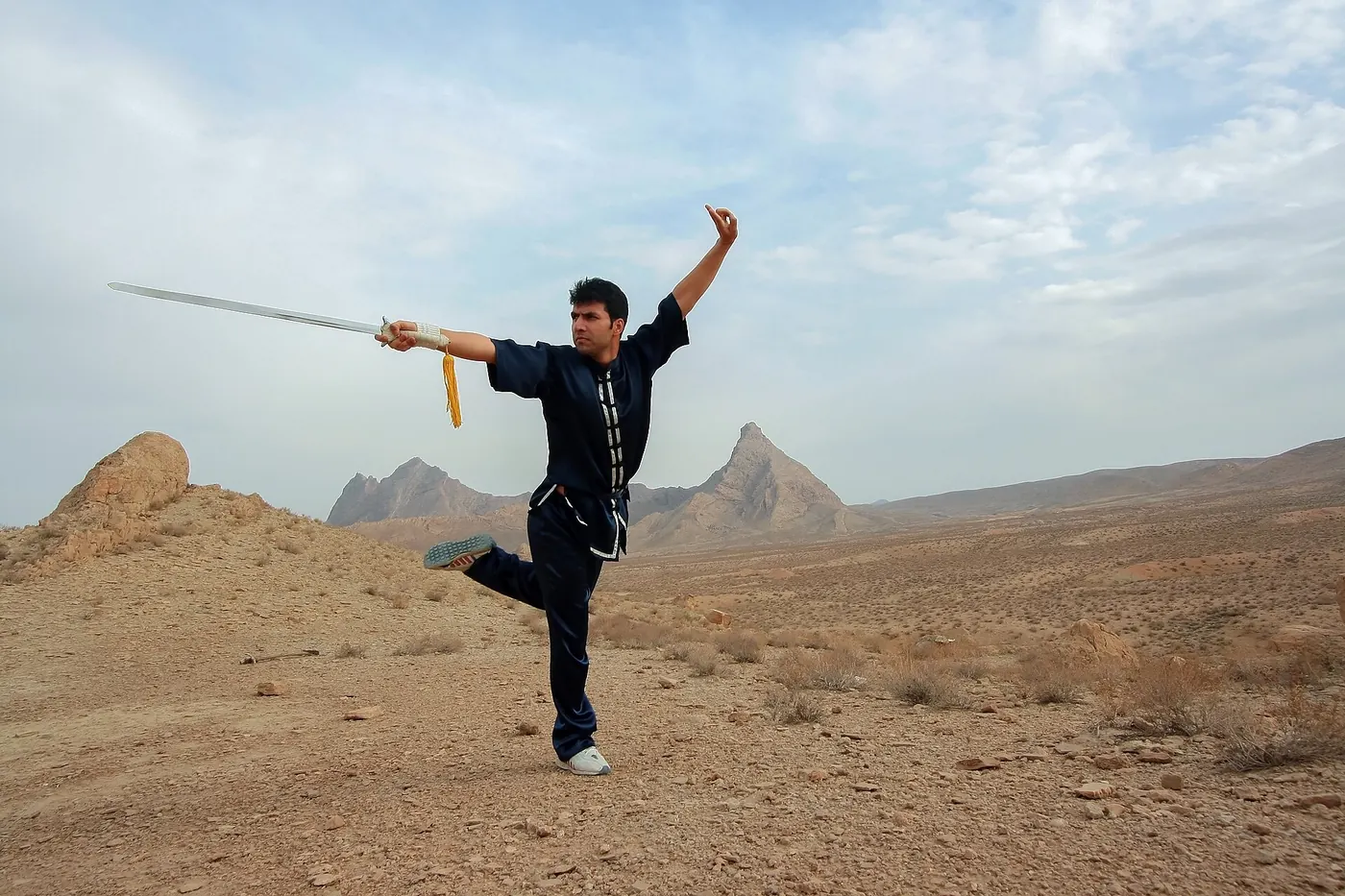 A martial artist performing a sword form outdoors