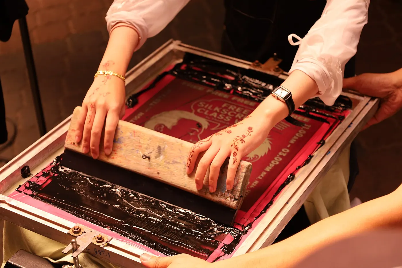 Hands pulling a screen print