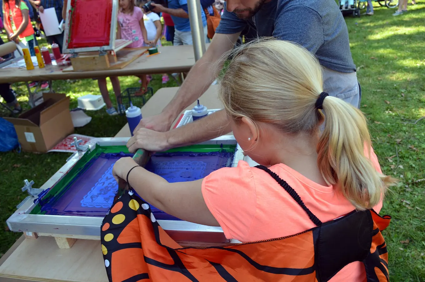 Screen printing a design at a print table